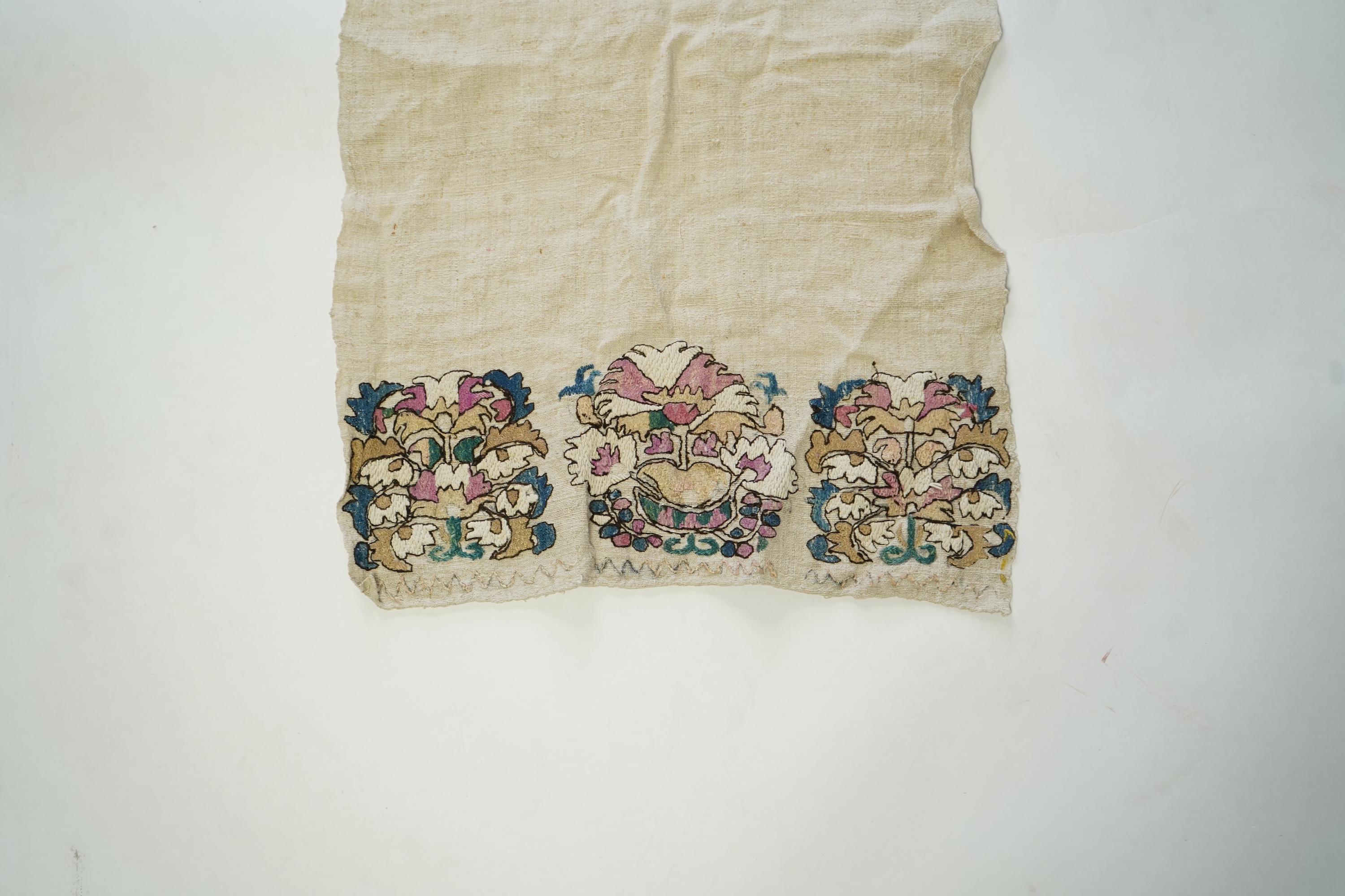An early 20th century heavy hand woven linen Turkish towel, with coloured silk embroidered ends. 123cm long x 43cm wide. Condition - has two stains and some embroidery worn in places.